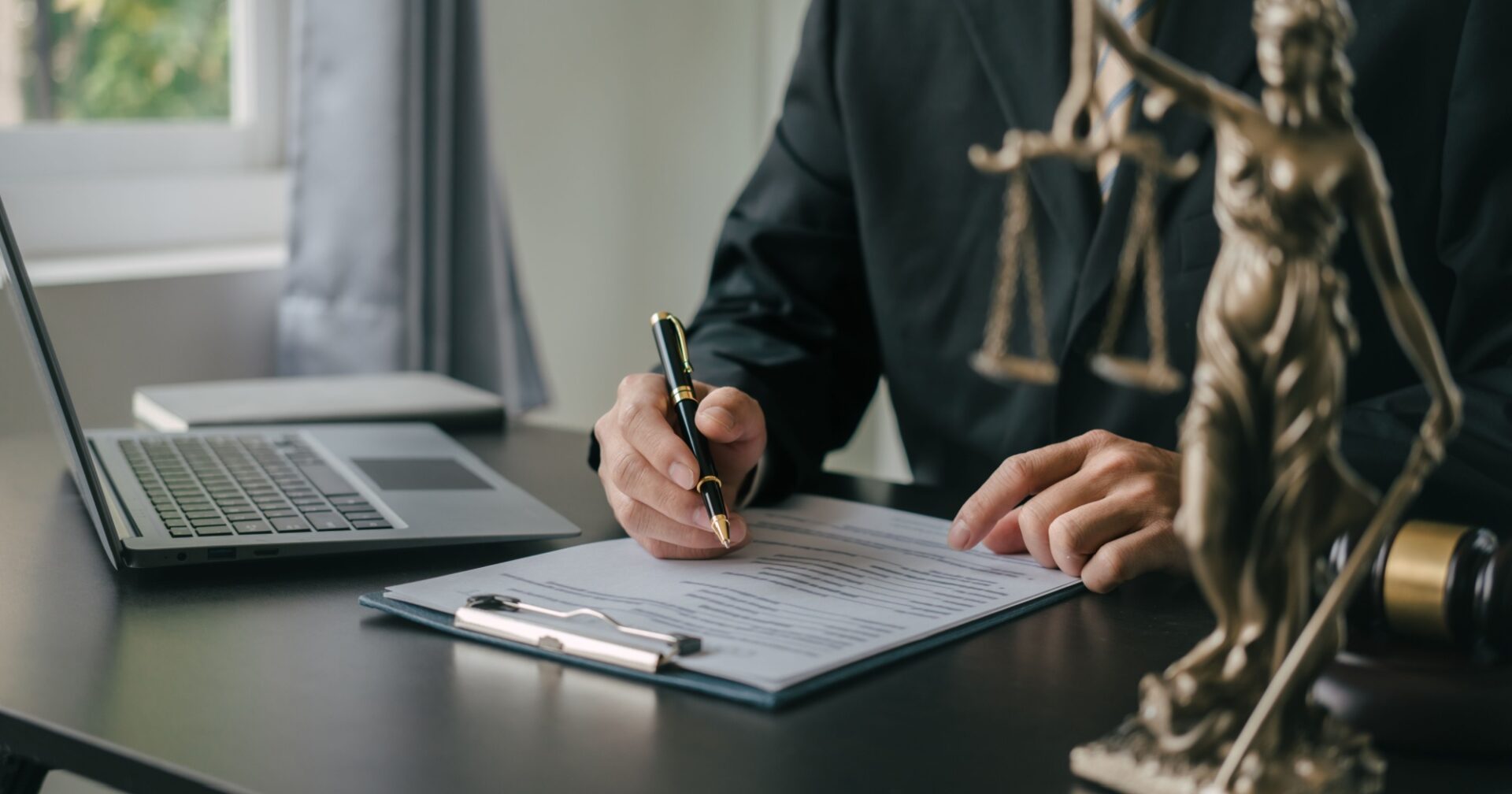A well-dressed lawyer at a desk reading over bankruptcy documents.